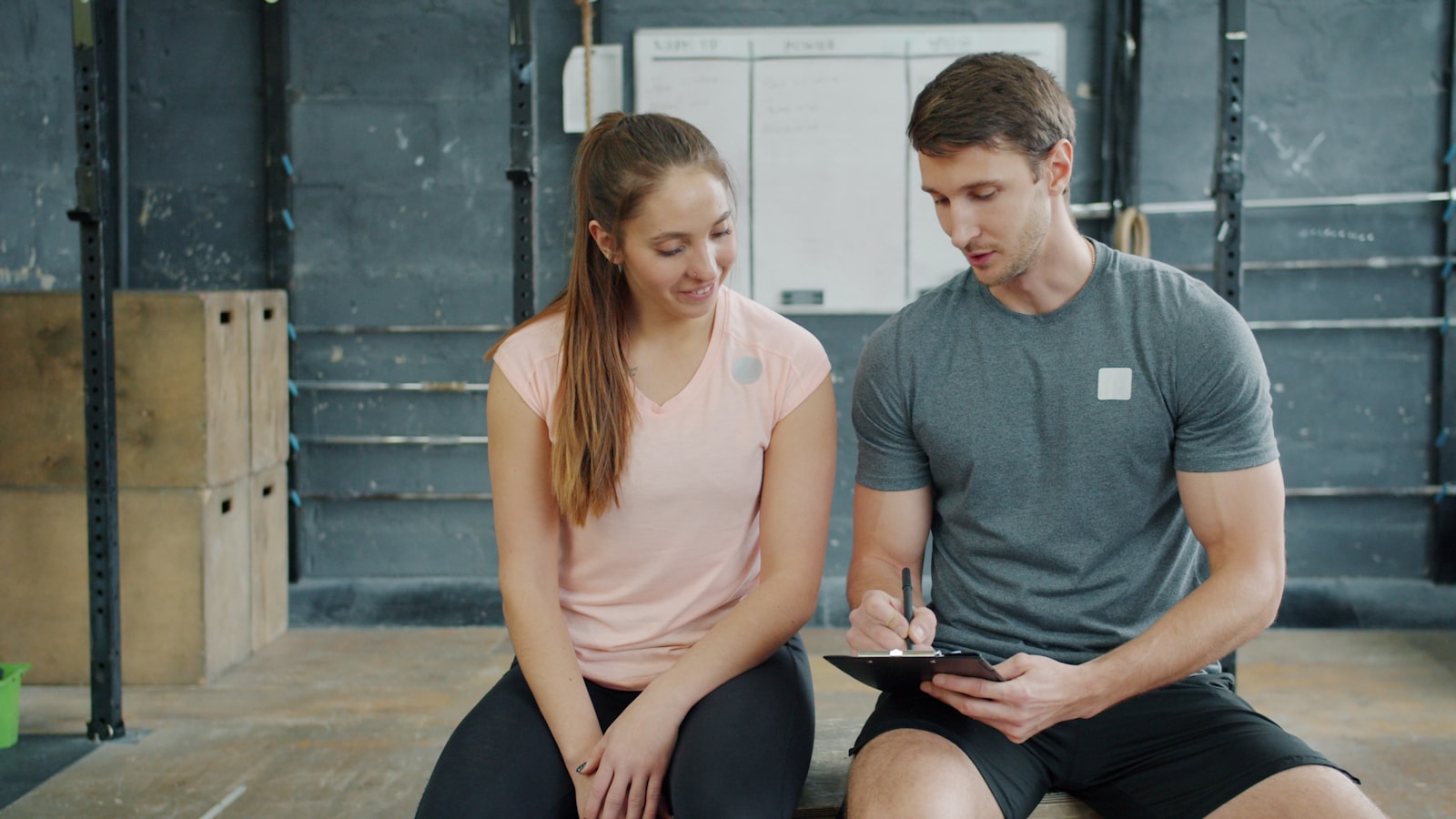 Fitness professional reviewing a training plan with a client in a gym